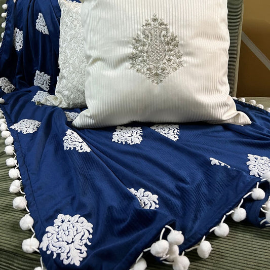 Blue Moon Embossed Throw on an olive green sofa with off-white coloured pillows