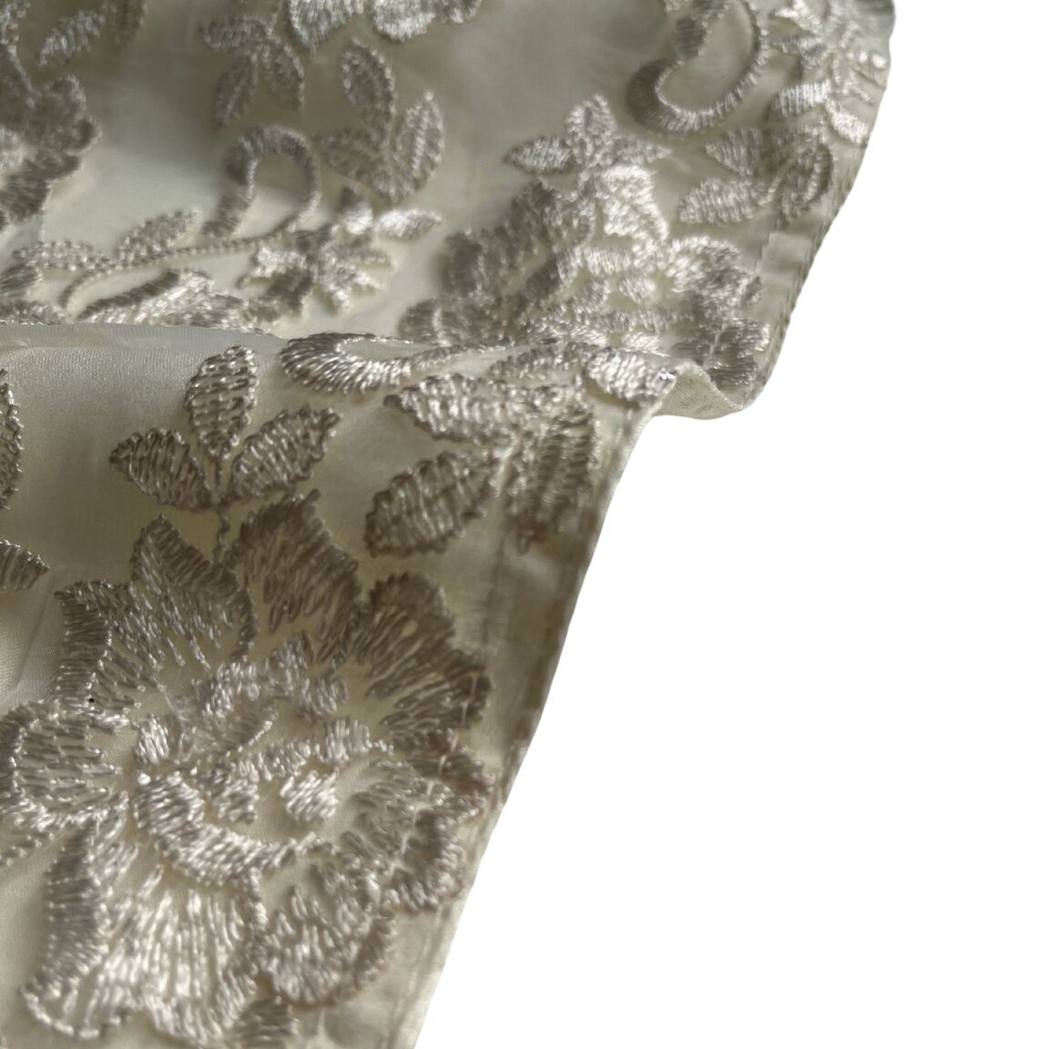 A close up to the  Floral emboidary in cream color