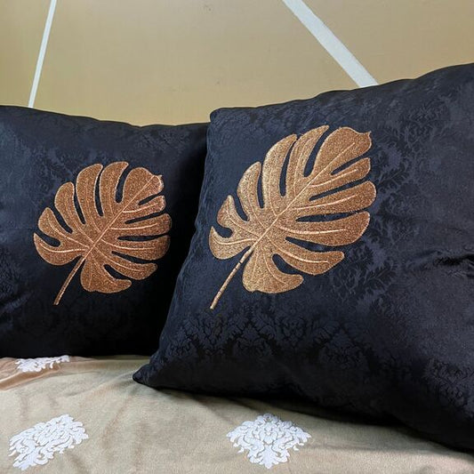 Two black cushions on a brown sofa throw