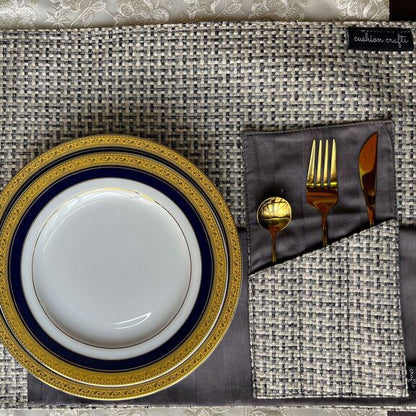 Placemats with a gold and blue plates, a cutlery holder with cutlery in it