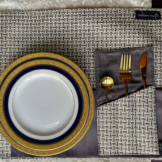 Placemats with a gold and blue plates, a cutlery holder with cutlery in it